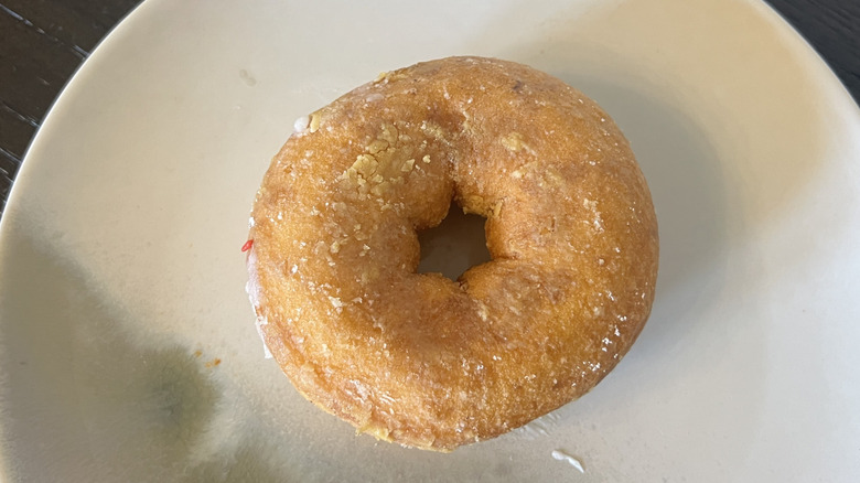 Duck Donuts powdered sugar donut on plate.