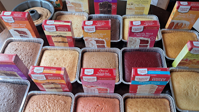 fourteen cakes and boxes of cake mix on table