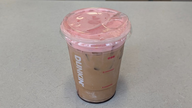 A Chocolate Covered Strawberry Iced Coffee from Dunkin' on a grey table