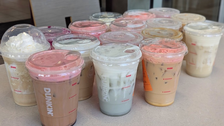 A variety of Dunkin' drinks in a similar color scheme on a table
