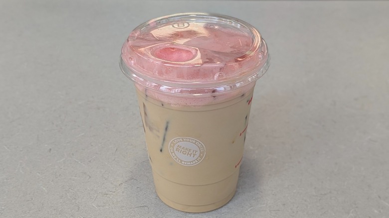A Vanilla Pink Cloud Latte from Dunkin' on a grey table