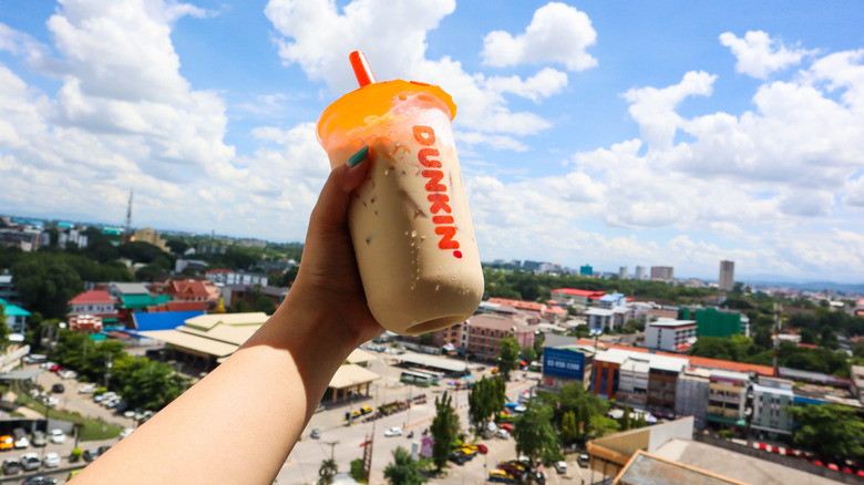 Person holds Dunkin' iced coffee drink