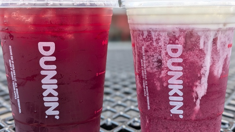 A close-up of two pruple Dunkin' drinks, one with oatmilk and cold foam