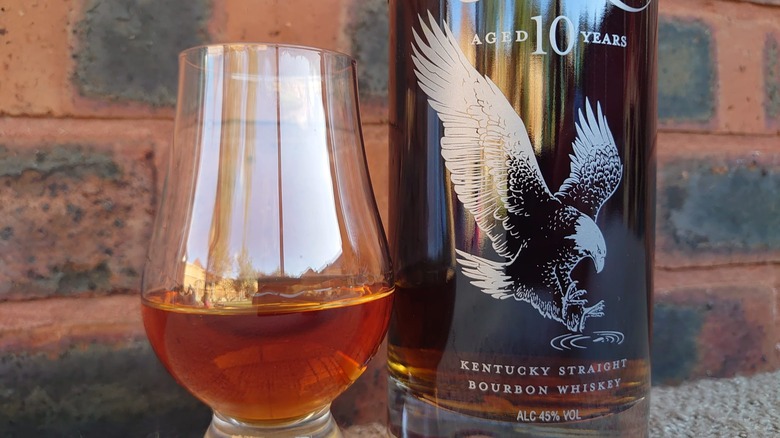 A close up of a glass of Eagle Rare 10-year and the bottle side by side