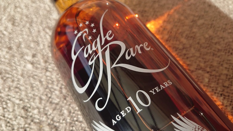A close up of the top half of an Eagle Rare 10-year bottle on a blanket