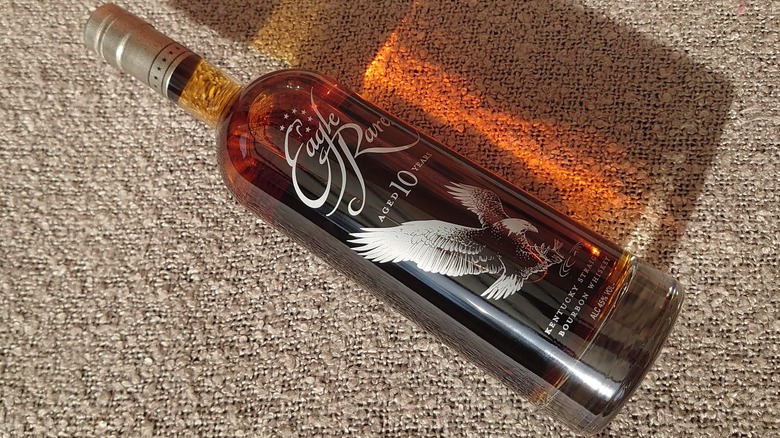A bottle of Eagle Rare 10-year laid on its side on a blanket in the sun