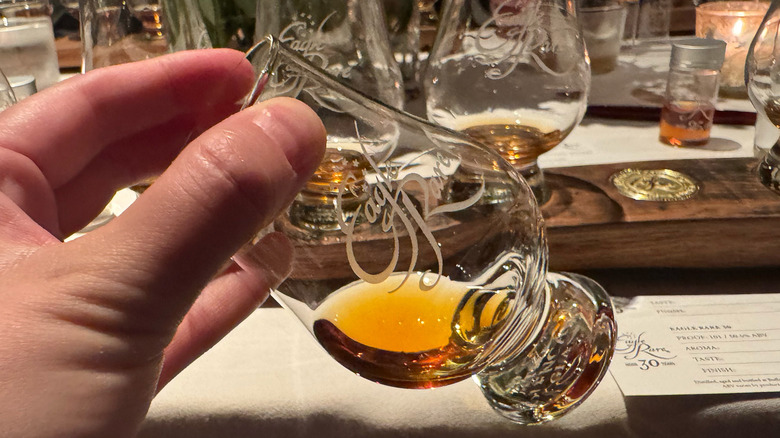 hand holding Eagle Rare 30 in glencairn glass