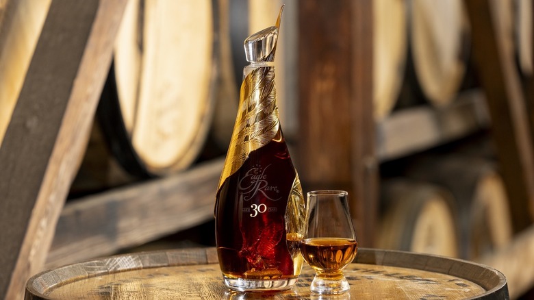 Bottle and glass of Eagle Rare 30 in barrel room