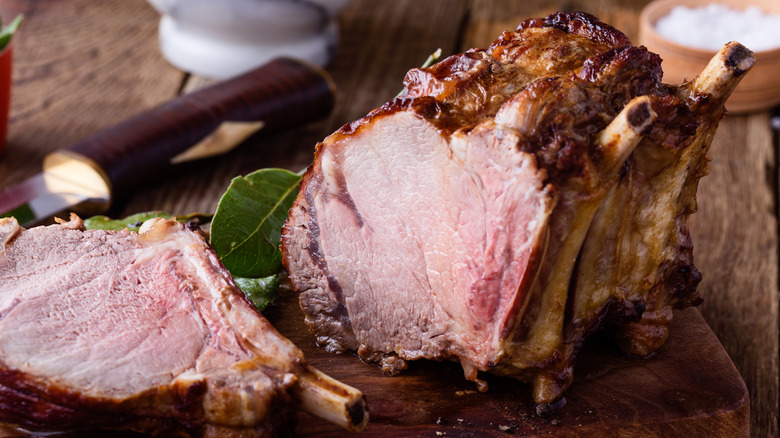 A whole prime rib roast with a slice cut out of it