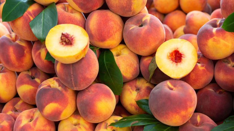 Fresh, whole and halved peaches