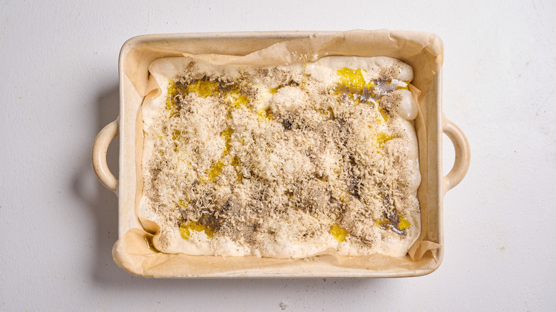 cheese, oil, and pepper on top of focaccia dough