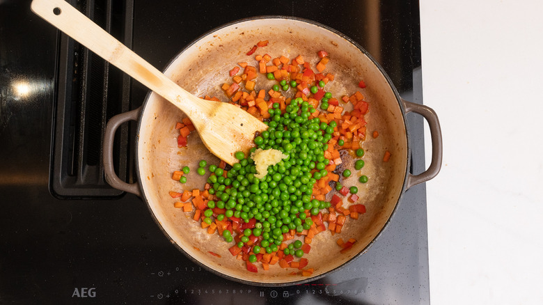 adding vegetables to a pan