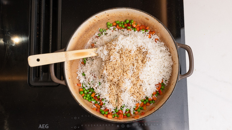 adding rice to pan for frying