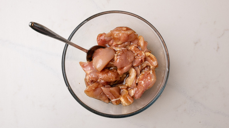 chicken marinading in bowl
