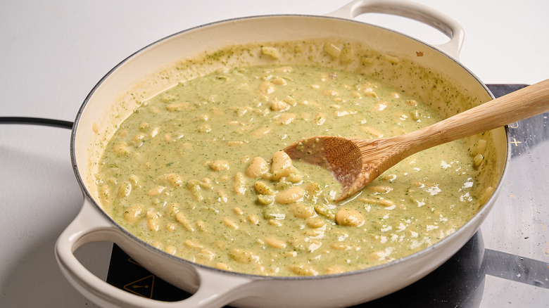 combining pesto in a skillet