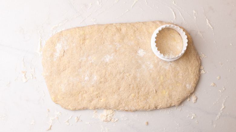 cinnamon biscuit dough with biscuit cutter on it