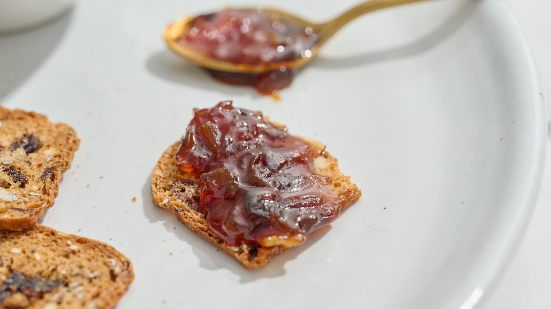 onion jam on a cracker with a spoon to the side