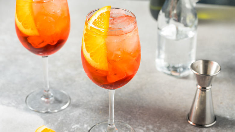 Aperol Spritz cocktails with measuring cup and bottle