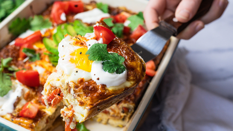 Lifting a serving of easy tortilla breakfast casserole.