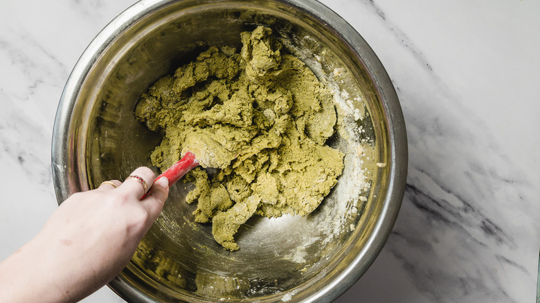 Hand mixing cookie batter with spatula in bowl