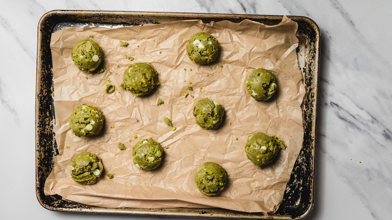 Baking sheet with raw white chocolate matcha cookies