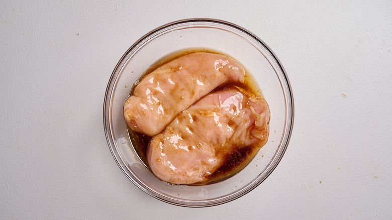 marinating chicken in a bowl