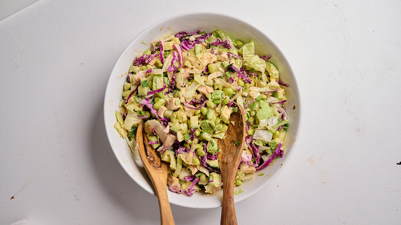 salad tossed with dressing in a bowl