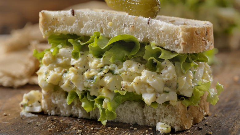 Egg salad sandwich with gherkin spear