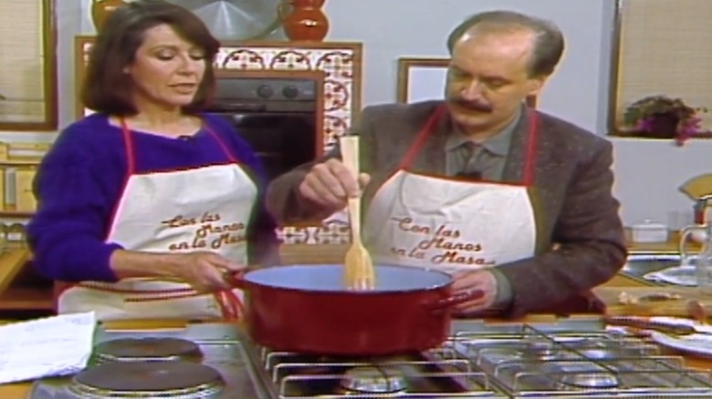 Elena Santonja and a guest standing at the stove stirring a pan