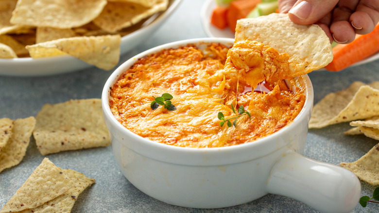 Chip being dipped into a creamy buffalo chicken dip
