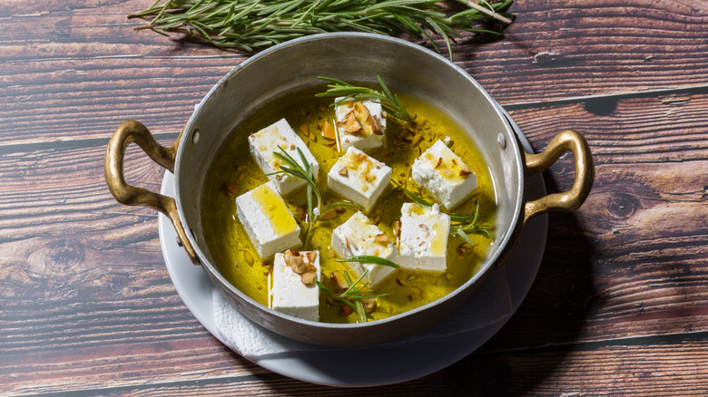 Marinating feta in a bowl with herbs