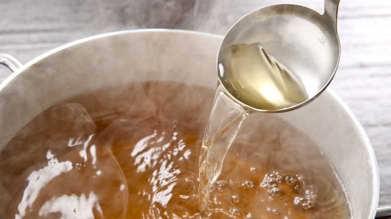 Dashi broth in a pot with ladle
