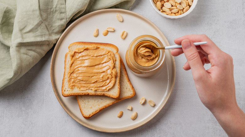 Spreading peanut butter on bread