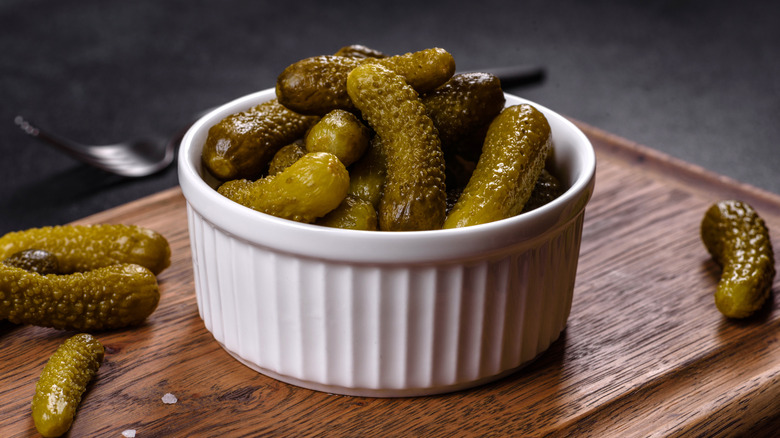 Bowl of small pickles on wooden table
