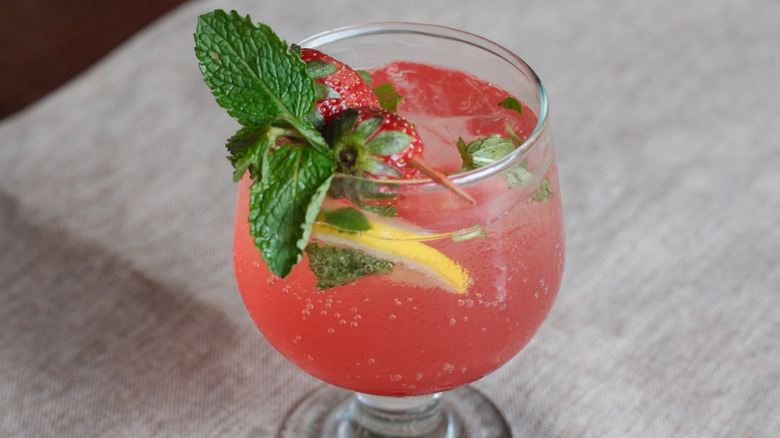 Strawberry lemon cocktail with mint, lemon slice, and two strawberries