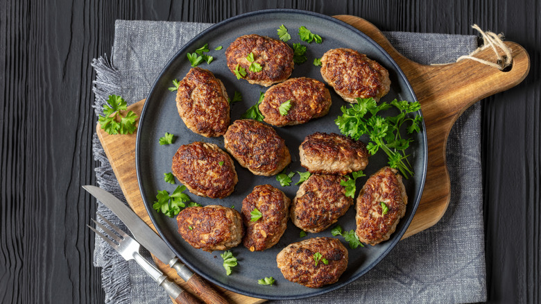 Danish meatballs or frikadeller on a blue plate garnished with fresh parsley