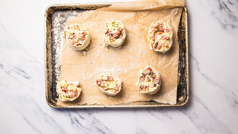 stuffed eggs Benedict rolls on baking sheet