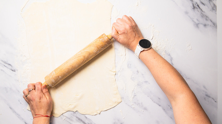 Rolling out puff pastry on marble