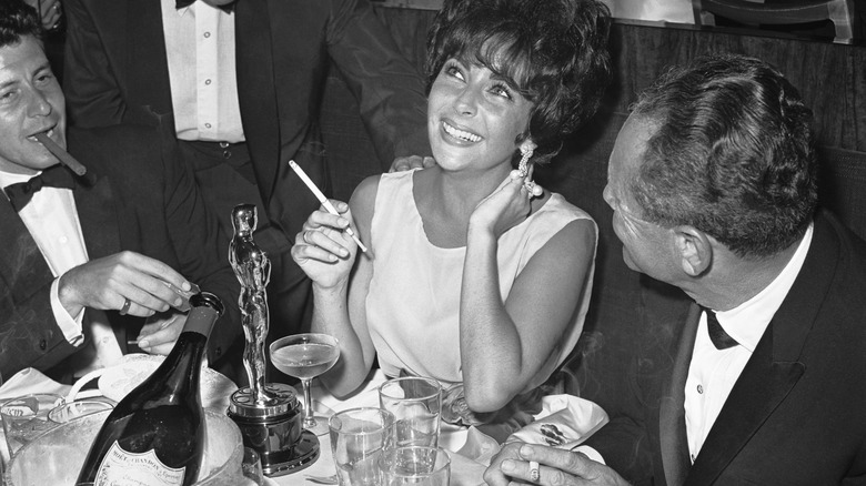 Elizabeth Taylor with bottle of Dom Perignon beside her Oscar