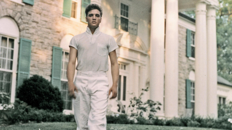 Elvis Presley standing in front of Graceland