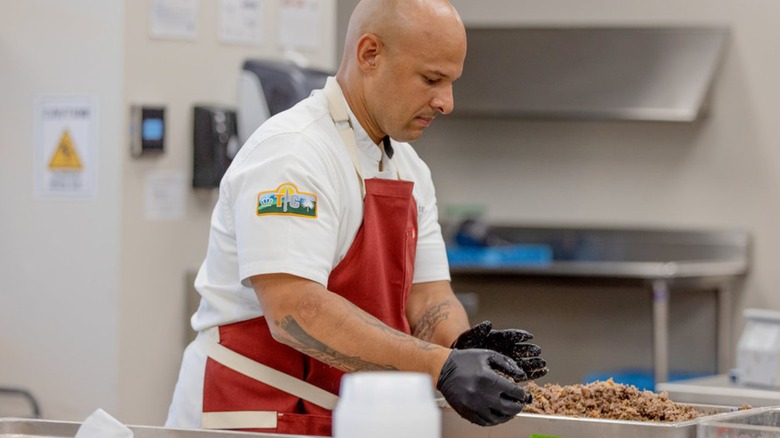 Top Chef competitor Brandon Dearden rolling shredded meat into a ball