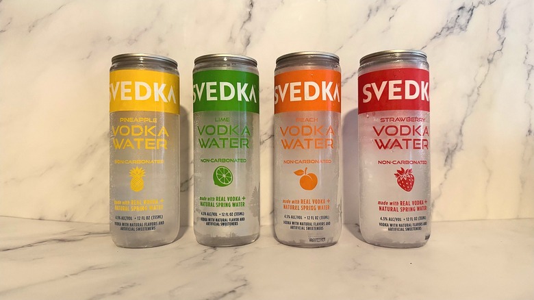 Four cans of Svedka Vodka Water on marble background
