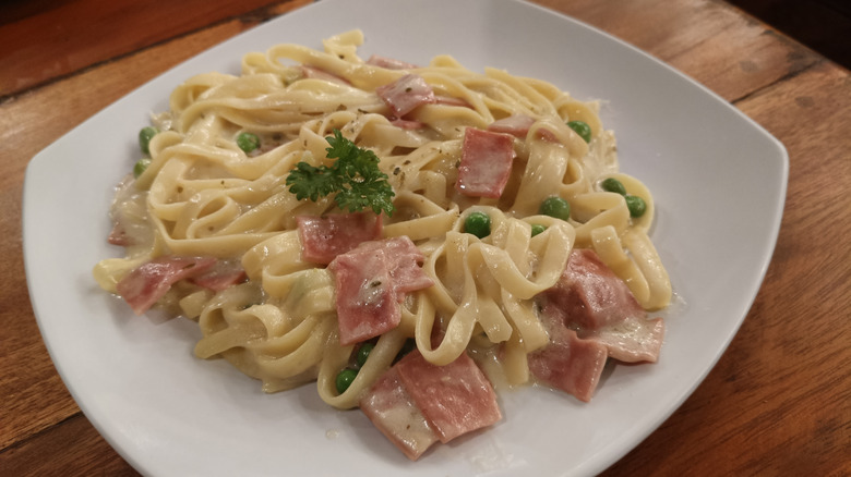 Carbonara pasta on plate with herb garnish