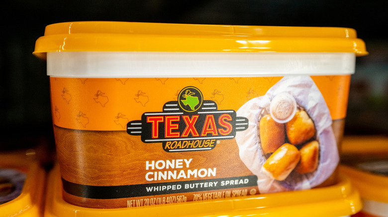 Several stacked tubs of Texas Roadhouse Honey Cinnamon Whipped Buttery Spread