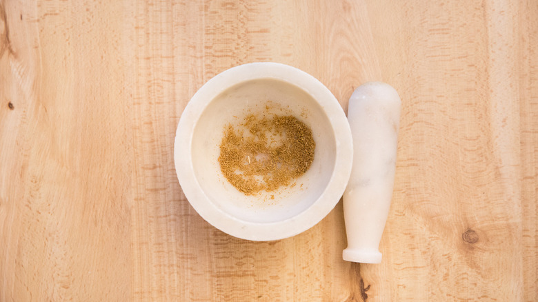 ground cumin in stone mortar