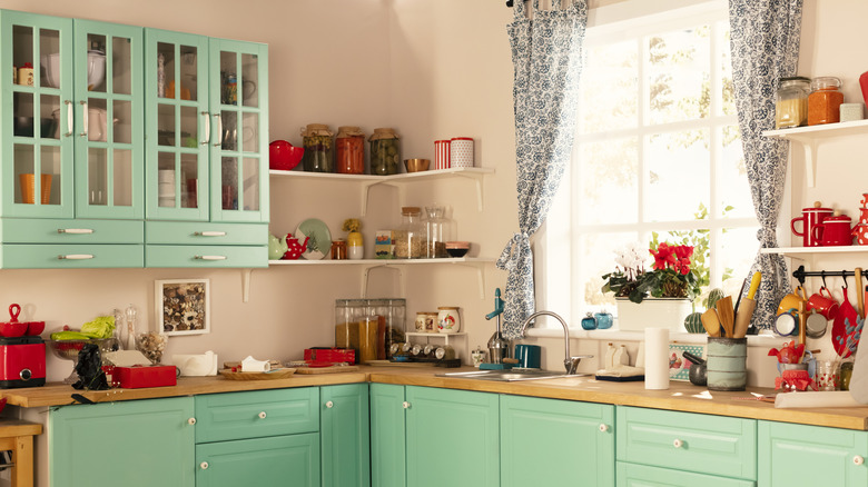Kitchen design with seafoam green cabinets and red appliances