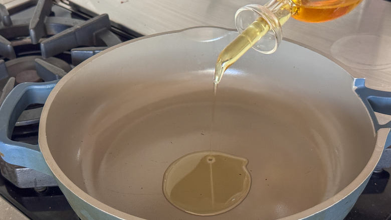 adding oil to skillet