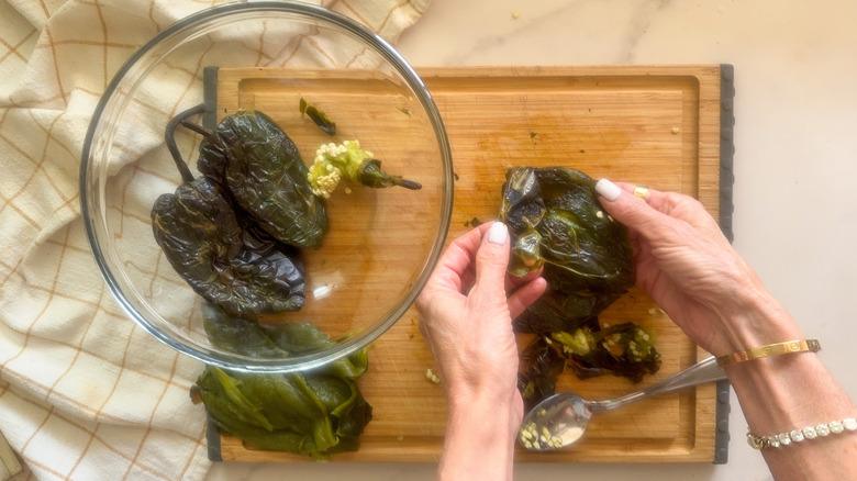hands peeling peppers