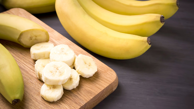 cut and whole bananas on cutting board