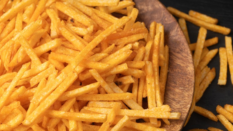 plate of french fries spilling on to table